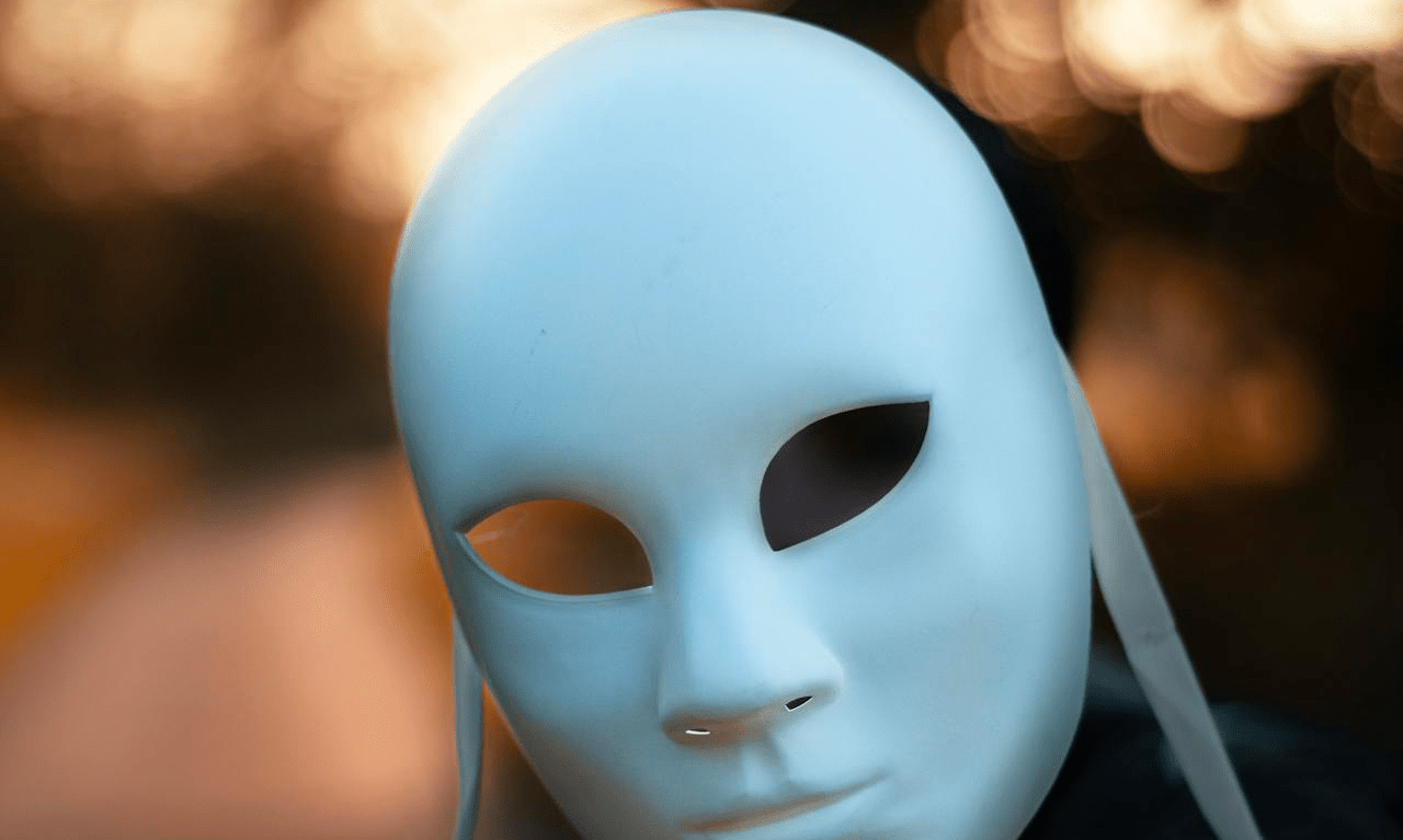 A white, lacquered mask, that looks like a relaxed face, representing the danger that supply chain threats put to our software development process.